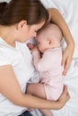 Mother and baby sleep in bed. Mom embraces her little daughter. Royalty Free Stock Photo