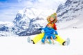 Mother and baby on sleigh ride. Winter snow fun Royalty Free Stock Photo