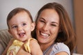 Mother, baby and smile in embrace at home, love and together for bonding in childhood. Mommy, daughter and support for