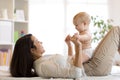 Mother and baby son playing in sunny bedroom. Parent and little kid relaxing at home. Family having fun together. Royalty Free Stock Photo