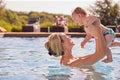 Mother With Baby Son On Summer Holiday Playing In Swimming Pool Royalty Free Stock Photo