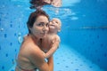 Mother, baby son swim and dive underwater in swimming pool Royalty Free Stock Photo