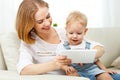 Mother and baby son with a tablet computer at home Royalty Free Stock Photo