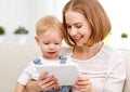 Mother and baby son with a tablet computer at home Royalty Free Stock Photo