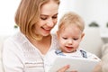 Mother and baby son with a tablet computer at home Royalty Free Stock Photo