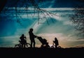 Mother with baby in stroller and kids on bikes walk in sunset nature Royalty Free Stock Photo