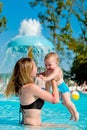 Mother and baby in swimming pool. Parent and child swim in a tropical resort. Summer outdoor activity for family with kids. Royalty Free Stock Photo