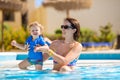 Mother and baby in swimming pool. Parent and child swim in a tropical resort. Summer outdoor activity for family with kids Royalty Free Stock Photo