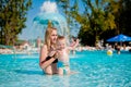Mother and baby in swimming pool. Parent and child swim in a tropical resort. Summer outdoor activity for family with kids. Royalty Free Stock Photo