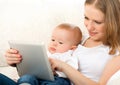 Mother and baby with tablet computer on the couch at home Royalty Free Stock Photo