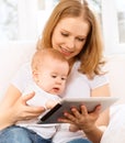 Mother and baby with tablet computer on the couch at home Royalty Free Stock Photo