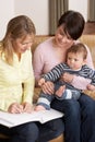 Mother With Baby Talking With Health Visitor At Ho Royalty Free Stock Photo