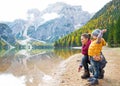 Mother and baby throwing stones on lake braies