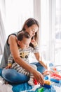 Mother and baby toddler playing learning toy stacking building blocks at home. Early age Montessori education. Kids hand brain and Royalty Free Stock Photo