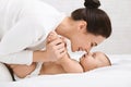 Mother and baby touching noses in bed Royalty Free Stock Photo