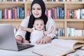Mother and baby using laptop in library