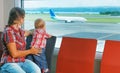 Mother with baby wait for boarding to flight in airport Royalty Free Stock Photo