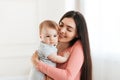 Mother and baby. Young happy mother holding infant child in arms, mom cuddling with her kid and smiling Royalty Free Stock Photo