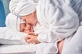 Mother in bathrobe and towel on head kissing in cheek her little sweet daughter Royalty Free Stock Photo