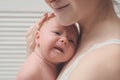 Mother with a blond newborn baby in her arms, a moment of tenderness. Close-up