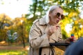 Mother blows soap bubbles to entertain baby in stroller.