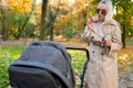 Mother blows soap bubbles to entertain baby in stroller.