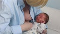 Mother breast feeding and hugging her baby.Young mother feeding breast her babyboy at home in blue-white room. Mom