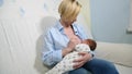 Mother breast feeding and hugging her baby.Young mother feeding breast her babyboy at home in blue-white room. Mom