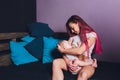 Mother breastfeeding baby in her arms at home. Beautiful mom Red hair breast feeding her newborn child. Baby eating Royalty Free Stock Photo