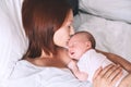 Mother breastfeeding newborn baby at home.