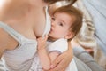 Mother breastfeeding baby in her arms at home. Mom breast feeding her newborn child. Baby eating mother`s milk. Concept of lactat Royalty Free Stock Photo