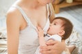 Mother breastfeeding baby in her arms at home. Mom breast feeding her newborn child. Baby eating mother`s milk. Concept of lactat Royalty Free Stock Photo