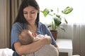 Woman holds a newborn baby. Mother hugging of her baby at home. Happy mum holding child on hands. Royalty Free Stock Photo