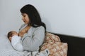 Mother breastfeeding her baby on the bed Royalty Free Stock Photo