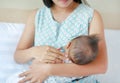 Mother breastfeeding her newborn child on the bedroom Royalty Free Stock Photo