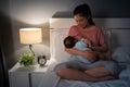 mother breastfeeding newborm baby on bed at night Royalty Free Stock Photo