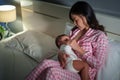 mother breastfeeding newborm baby on bed at night Royalty Free Stock Photo