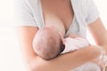 Mother breastfeeding newborn baby at home.