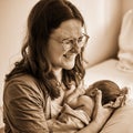 A mother is breastfeeding a newborn baby in a maternity hospital. A newly born child in the clinic in the arms of a mother who Royalty Free Stock Photo