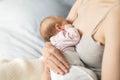 Mother breastfeeding newborn baby in room