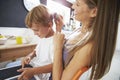 Mother Brushes Son's Hair As He Plays With Digital Tablet Royalty Free Stock Photo