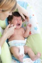 Mother calms newborn baby. Child is crying and screaming during colic Royalty Free Stock Photo