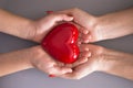 Mother care or love concept with child and mom hands holding a red heart shape Royalty Free Stock Photo