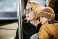 Mother carries her child while standing and holding on to the bus. Mom holding her infant baby boy in her arms while Royalty Free Stock Photo