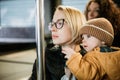 Mother carries her child while standing and holding on to the bus. Mom holding her infant baby boy in her arms while Royalty Free Stock Photo