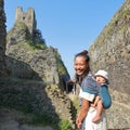 Mother carrying baby in sling on Trosky Castle