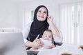 Mother Carrying Baby while Working Royalty Free Stock Photo