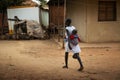 Mother carrying her baby on her back at the Missira neighborhood in the city of Bissau