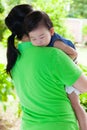 Mother carrying her daughter in home backyard