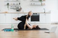 Mother carrying infant on bent knees while lying on yoga mat